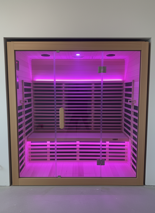 Infrared sauna with pink LED lights inside a room.