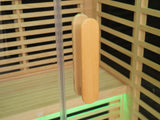 Wooden sauna door handle on a sauna door with black interior slats
